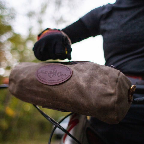 waxed canvas handlebar bag attached to a bike
